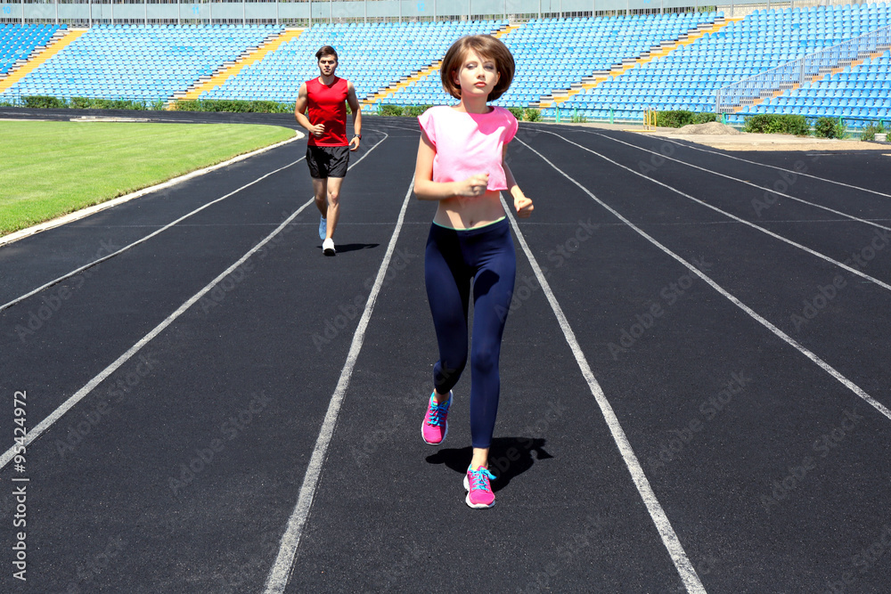Fototapeta premium Young people jogging on stadium