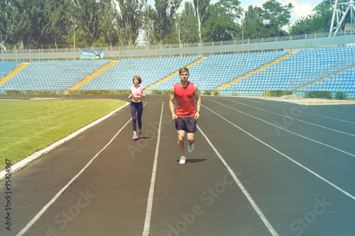 Young people jogging on stadium © Africa Studio