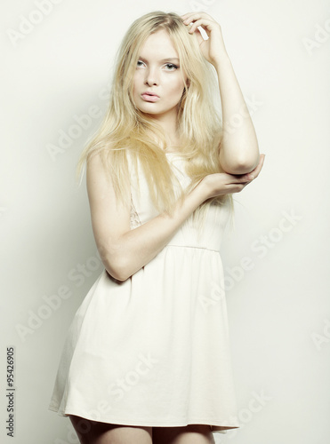  blond woman in white dress posing in studio