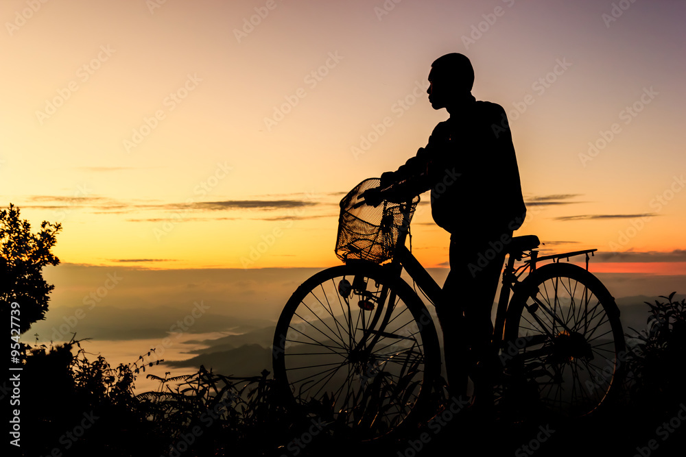 Boy riding bicycle on sunrise background.Silhouette Boy riding bicycle on sunrise background.Silhouette