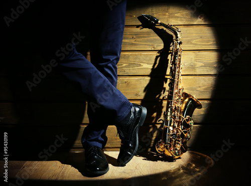 Photography The musician with sax on wooden background, close up