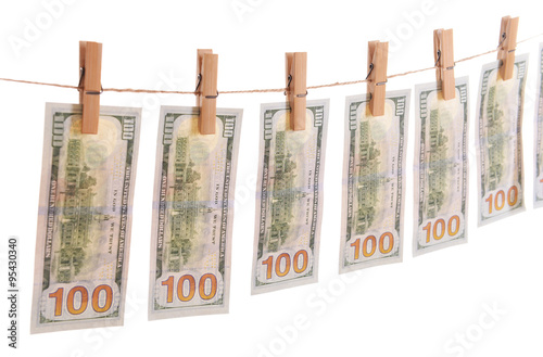 Concept of money laundering - dollars are drying on cord isolated on white background