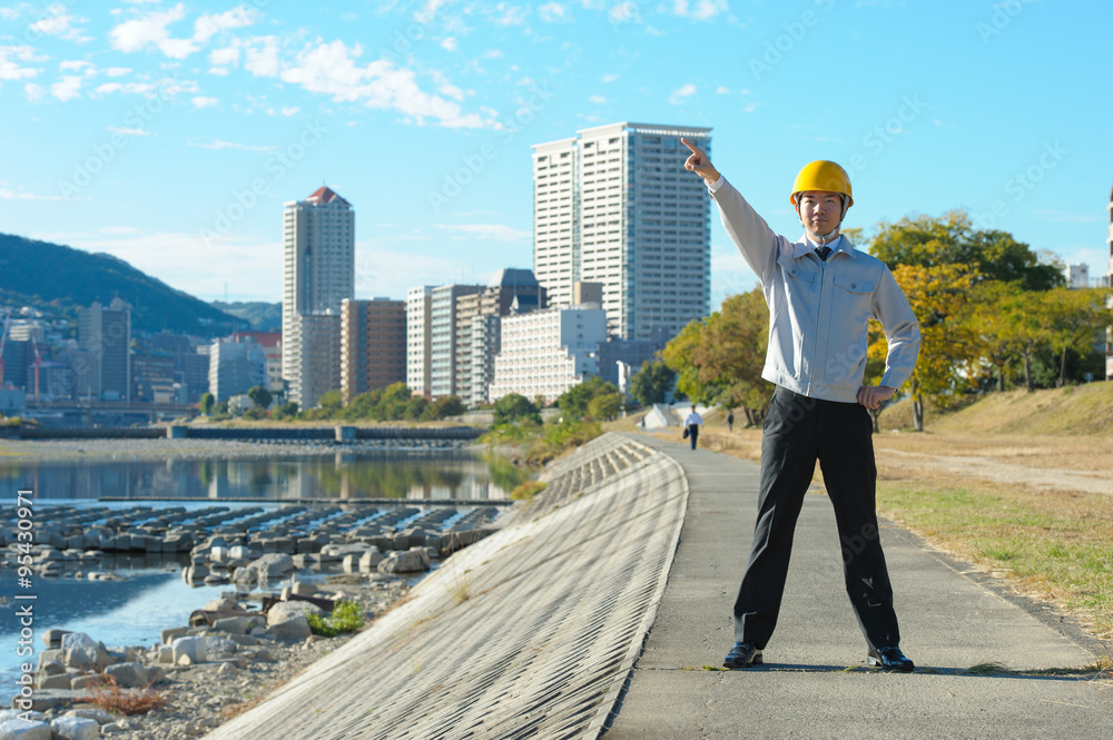 河川敷でビジネスをしている作業服の男性 河川敷でビジネスをしている作業服の男性