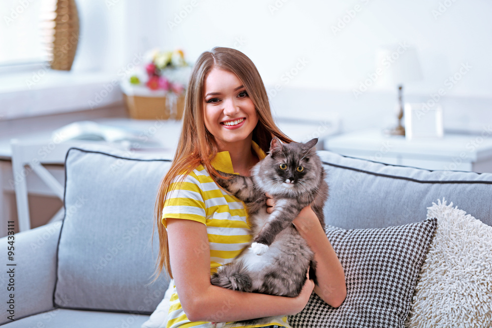 Beautiful young woman with cat at home