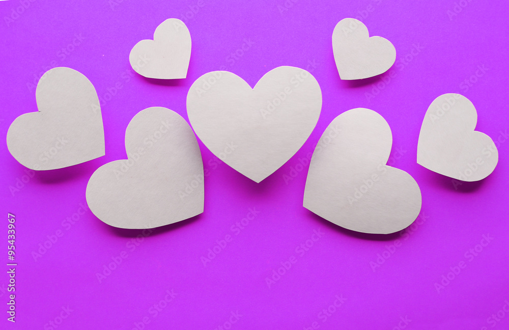 Obraz premium Paper hearts on purple paper background, close-up
