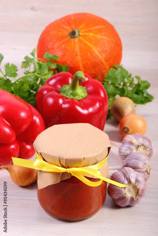 Sauce of pumpkin in glass jar and ingredients on wooden table Sauce of pumpkin in glass jar and ingredients on wooden table