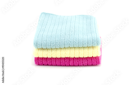 Pile of neatly folded colorful cotton towels in blue,yellow and red color isolated on white background.copy space to the right