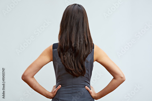 Business woman standing back with long hair. Studio isolated.