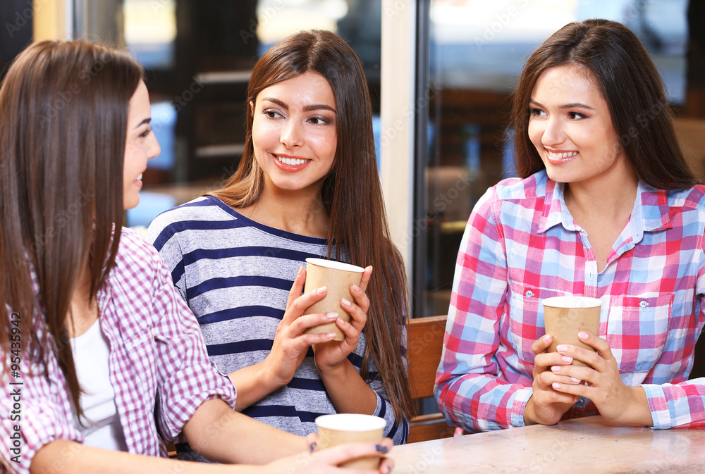 Fototapeta premium Three smiling friends speaking with coffee in hands