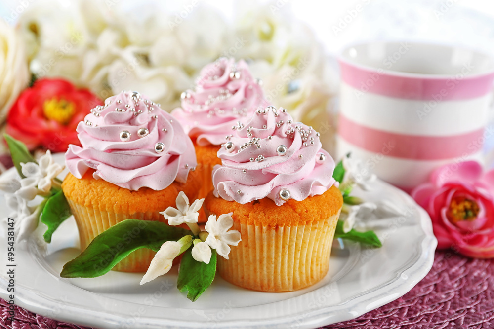 Tasty cupcakes on plate, on light background Tasty cupcakes on plate, on light background
