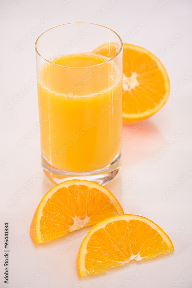 Orangensaft mit halbierter Orange und Orangenvierteln Orangensaft mit halbierter Orange und Orangenvierteln