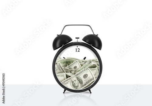 Foto An alarm clock with dollar bills inside is on the table