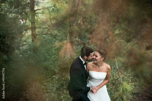 bride and groom dance together in the woods