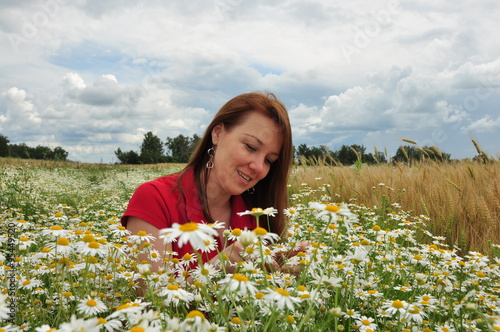 Молодая женщина на поле среди ромашек
