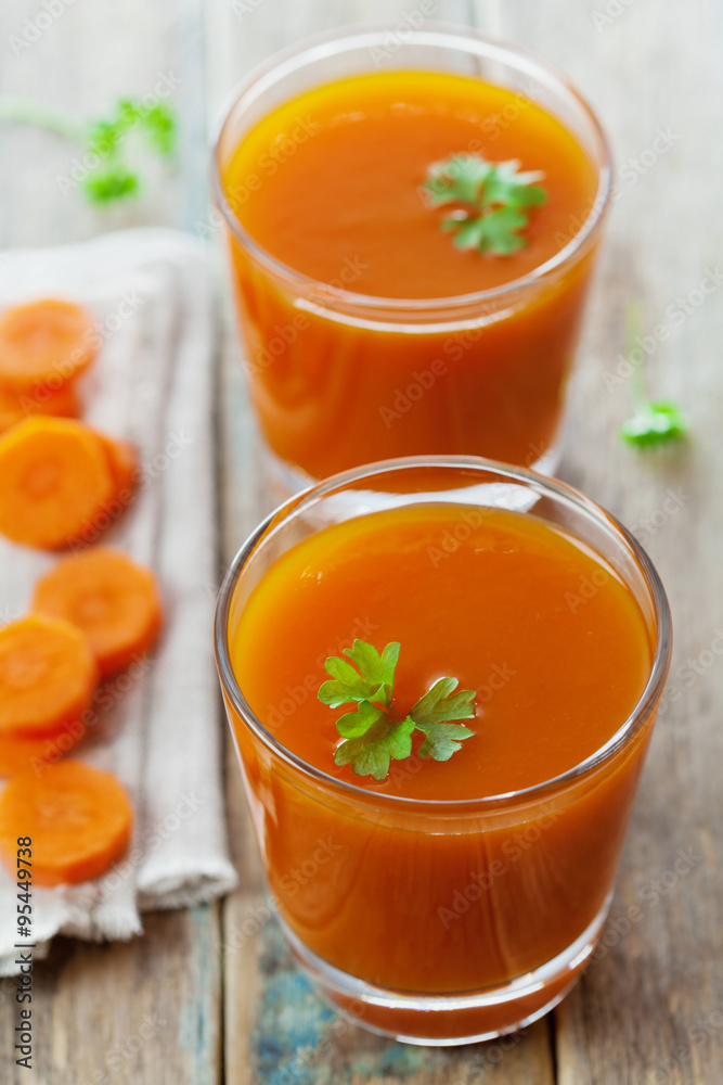 Fresh carrot juice in glass on wooden table, healthy vegetable drink Fresh carrot juice in glass on wooden table, healthy vegetable drink