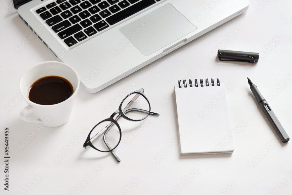 Coffee cup, spiral notebook, computer keyboard, glasses, and pen Coffee cup, spiral notebook, computer keyboard, glasses, and pen