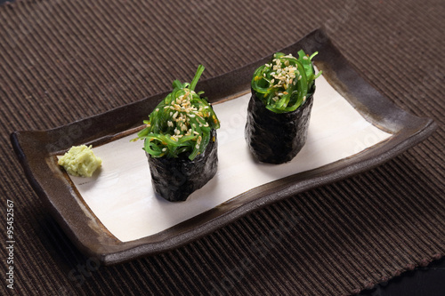 Wakame maki sushi, with wasabi on ceramic dish, seaweed  with sushi rice rolled in dried seaweed sheet