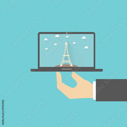 Tower Paris at the picture in a notebook. hand holds the computer