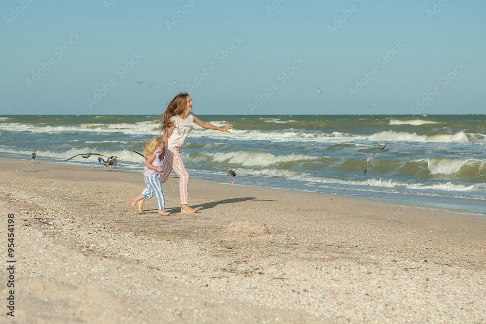 Mother and daughter having fun playing on the beach Mother and daughter having fun playing on the beach