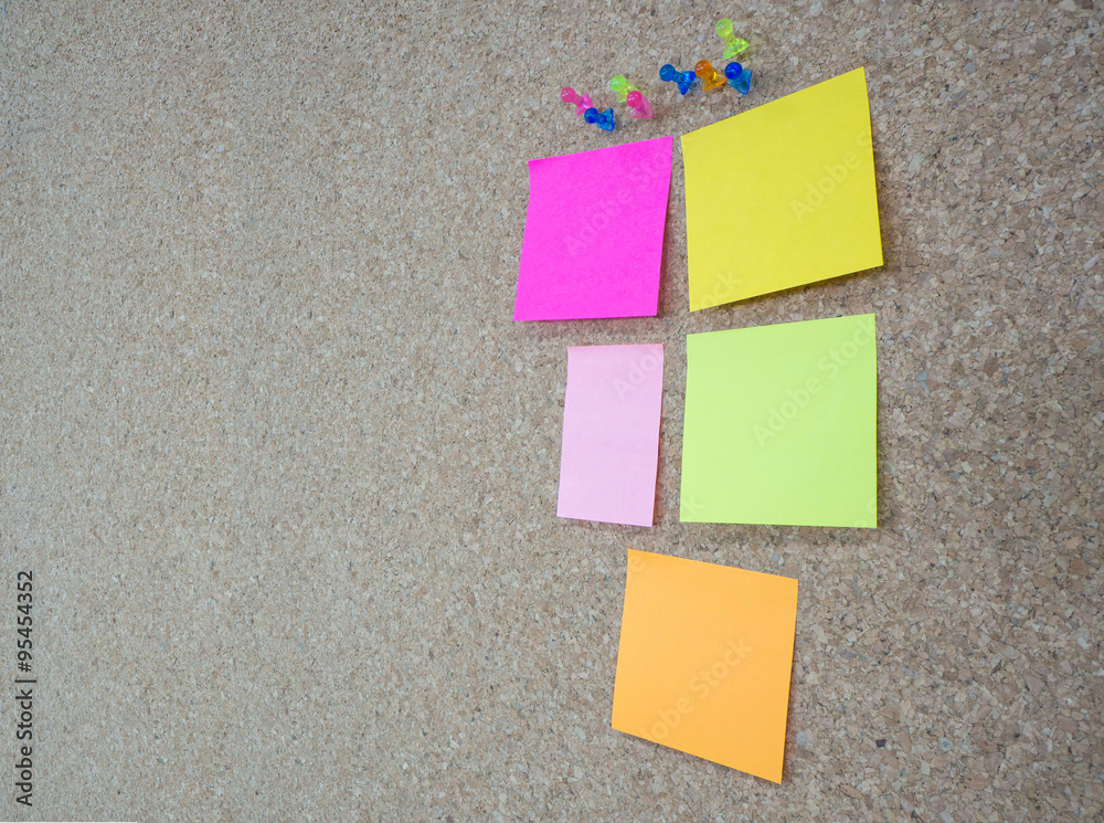 Fototapeta premium Group of thumbtacks pinned and colorful memorandum notes on cork