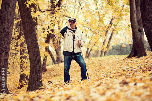 Senior man hiking in forest, intentionally toned image. © djoronimo
