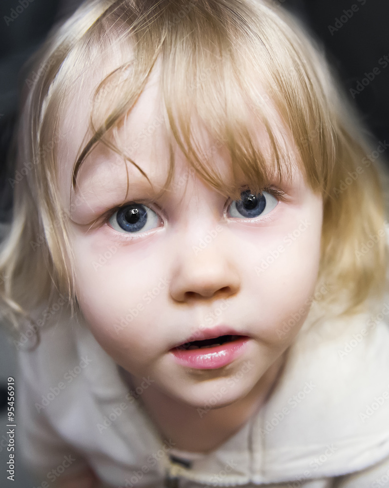 Beautiful little girl the blonde with huge blue eyes looking up Beautiful little girl the blonde with huge blue eyes looking up