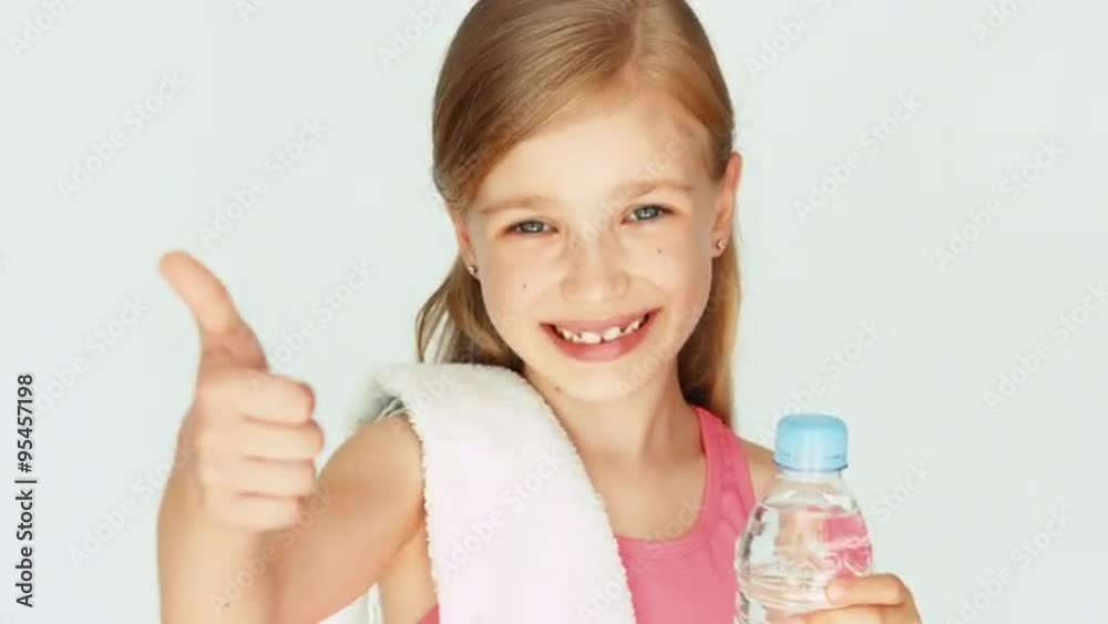 Closeup portrait girl child sportsman showing bottle of water. Thumb up. Ok Closeup portrait girl child sportsman showing bottle of water. Thumb up. Ok