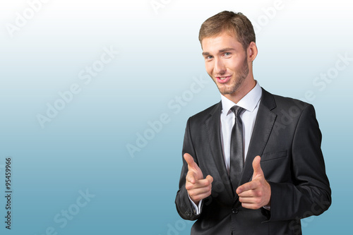 Young handsome businessman pointing on you