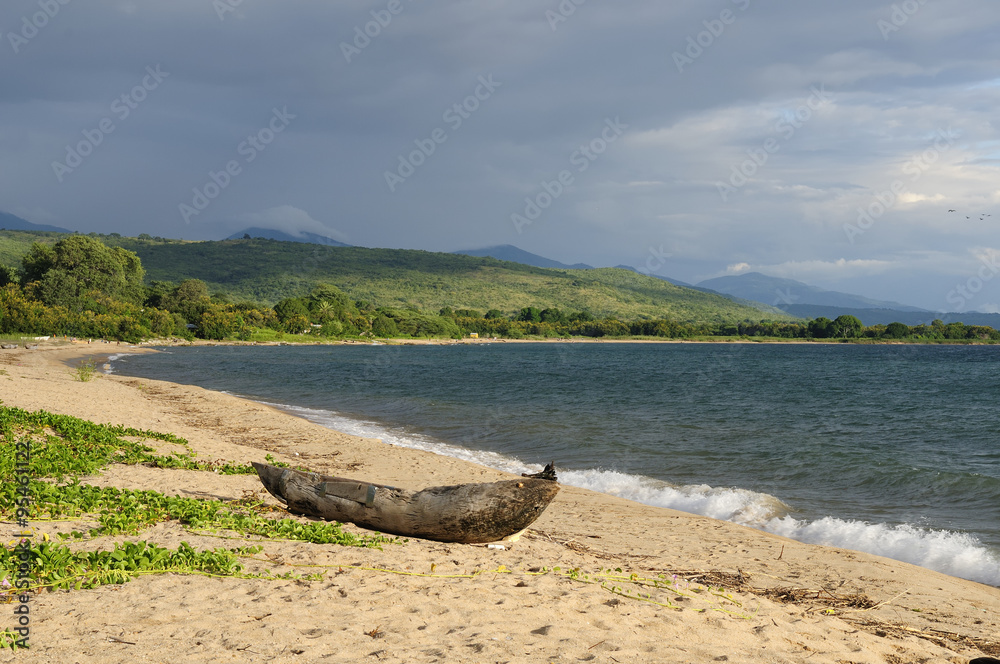 Naklejka premium Traditional dugout canoe on the beach on the lake Malawi