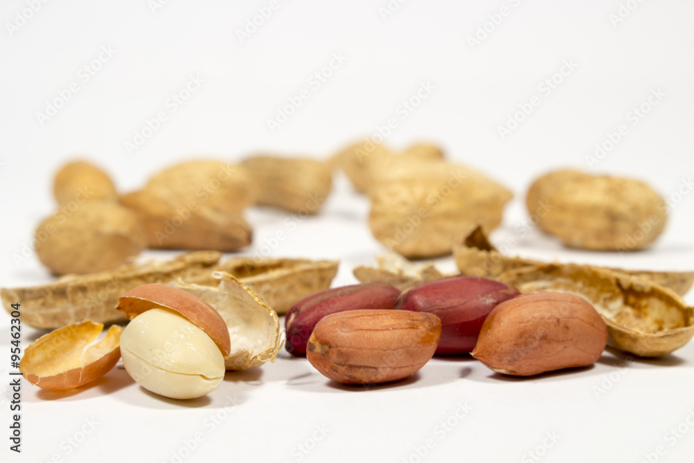 Peanut grains in front of empty shells and other nuts. On white background Peanut grains in front of empty shells and other nuts. On white background