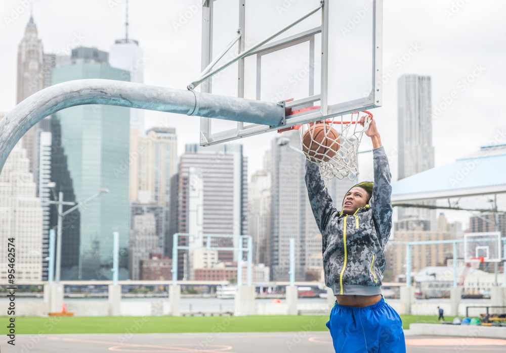 Fototapeta premium Basketball player making a slam dunk