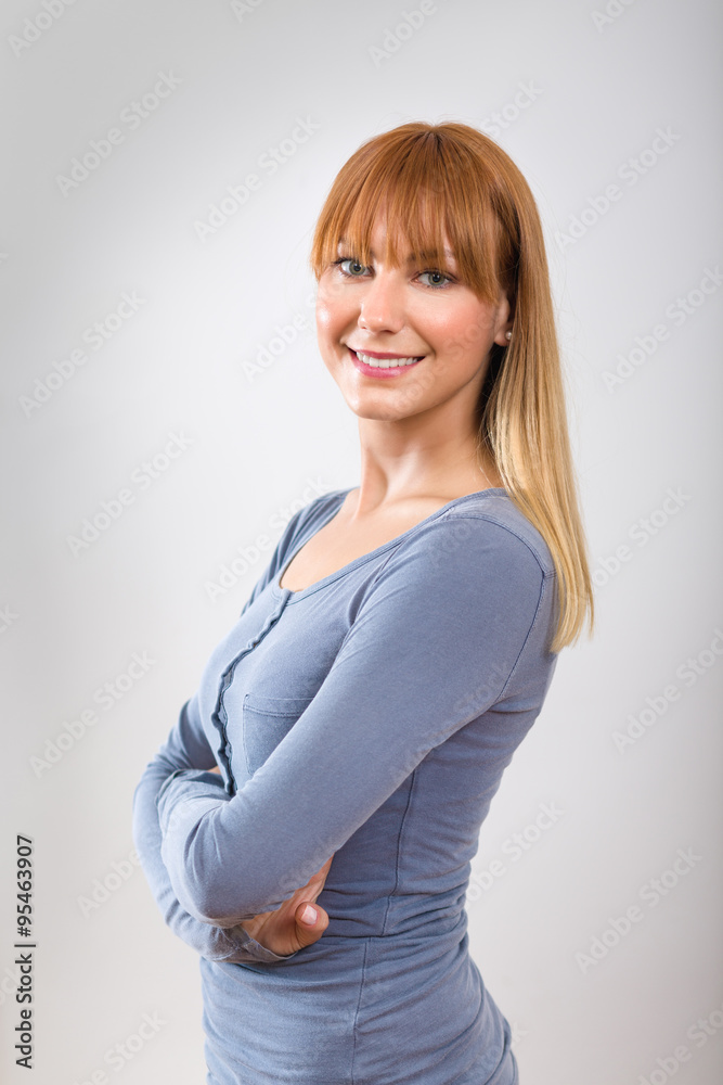 Closeup of a happy young woman smiling isolated on grey background