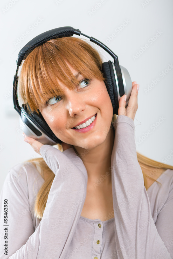 Portrait of a beautiful girl with headphones isolated ong grey background Portrait of a beautiful girl with headphones isolated ong grey background