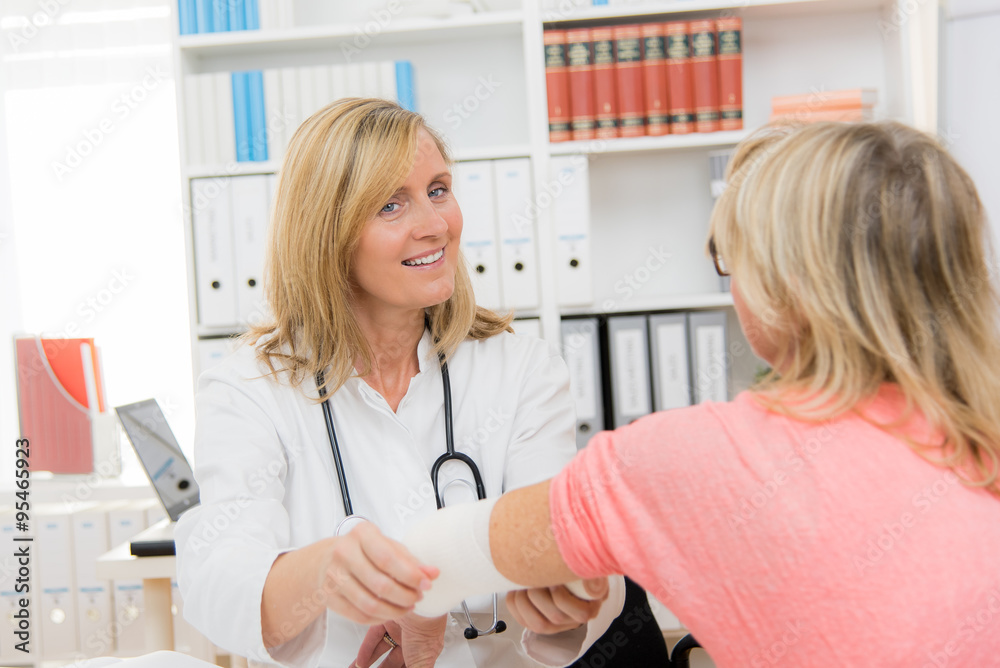 Fototapeta premium ärztin motiviert patientin bein verbandswechsel