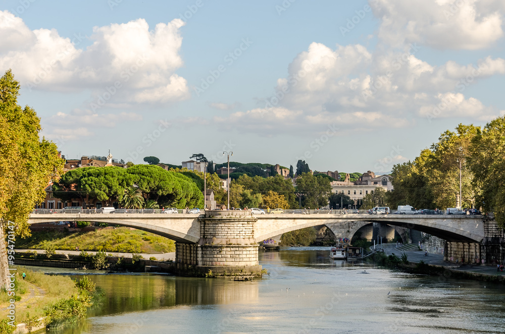 Quay of the river Tiber in Rome, Italy and the bridge across it, floating on the river excursion boat for tourists