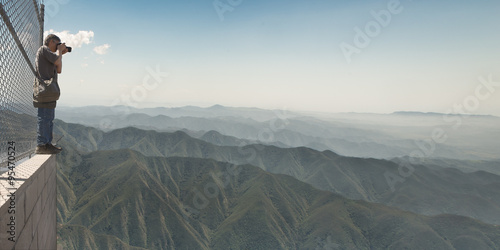 Man taking photo of mountain range