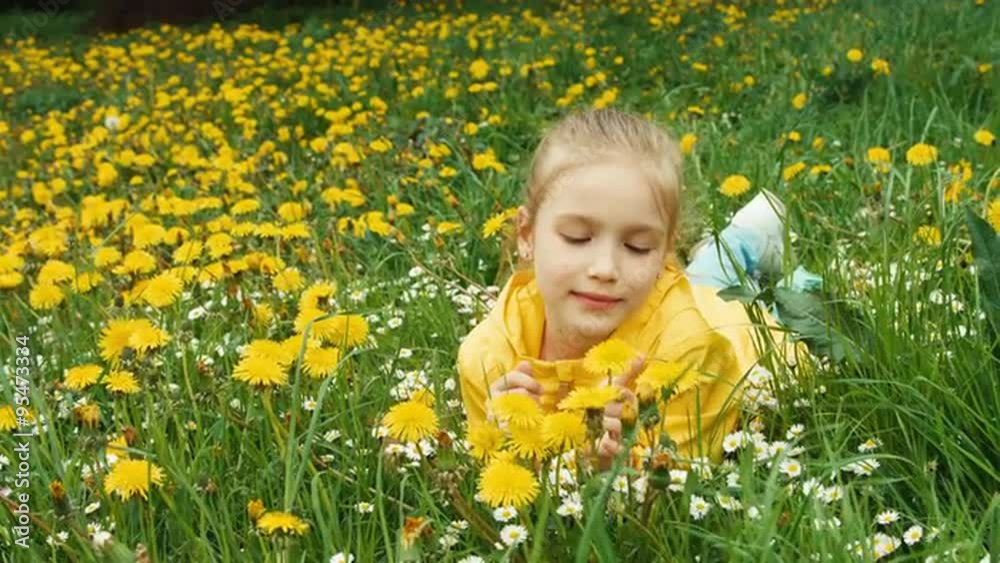 Closeup portrait child lying on the grass among yellow flowers Closeup portrait child lying on the grass among yellow flowers
