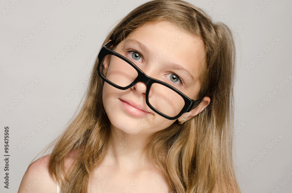 Beautiful little girl wearing big eyeglasses and looking smart Beautiful little girl wearing big eyeglasses and looking smart
