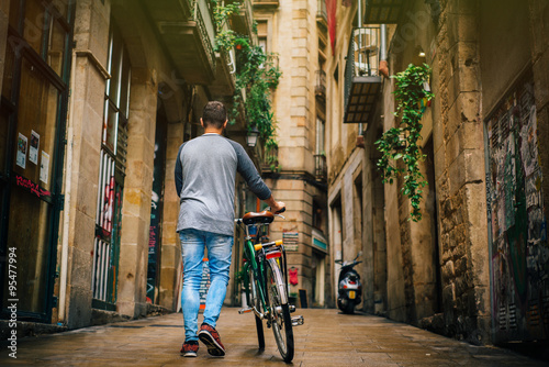 Young male is riding a bicycle in Barcelona
