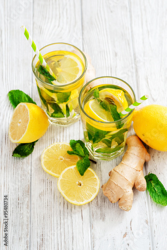  iced tea with lemon, mint and ginger on a wooden background