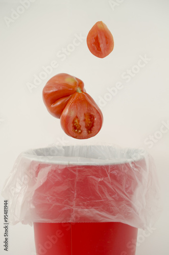 Throwing away an ugly-looking tomato  photo