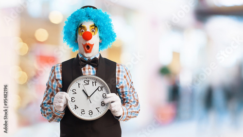 Foto portrait of a funny clown holding a clock