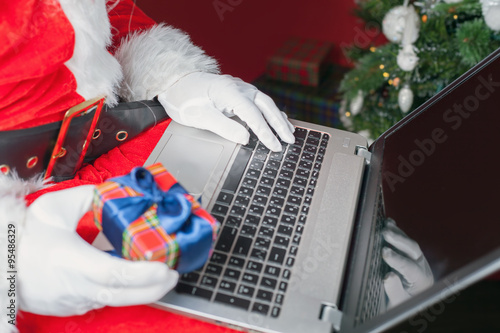 Santa buying gift by online payment through the Internet Banking © petunyia