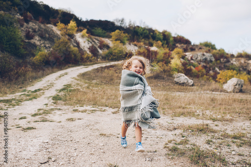 Adorable girl stay covered with  blanket in park