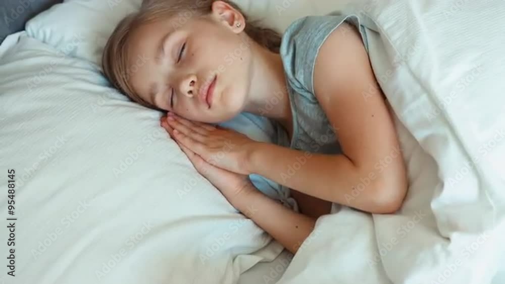 Closeup portrait girl 6-8 years old sleeping in a bed and wakes up. Top view Closeup portrait girl 6-8 years old sleeping in a bed and wakes up. Top view