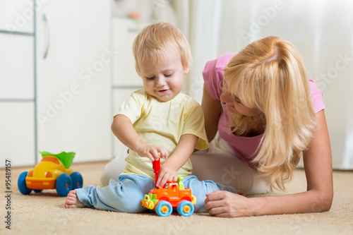 Child boy and his mother repair toy car at home
