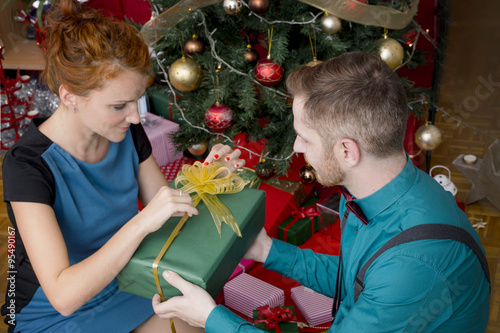 Couple of redheads exchanging Christmas gifts photo