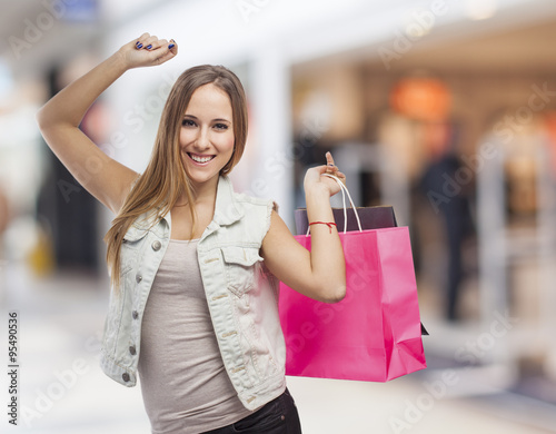 beautiful young woman dancing with shopping bags