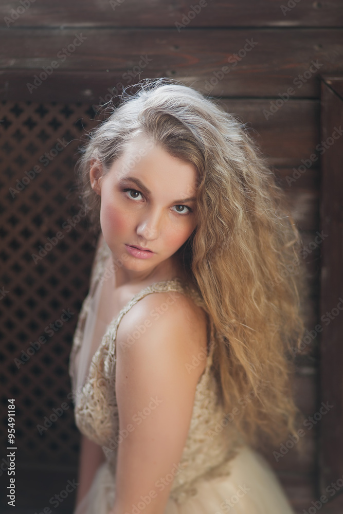 Fototapeta premium Młoda kobieta kręcone w pięknej beżowej sukience