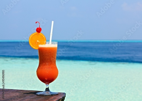 Glass of drink is on a beach table